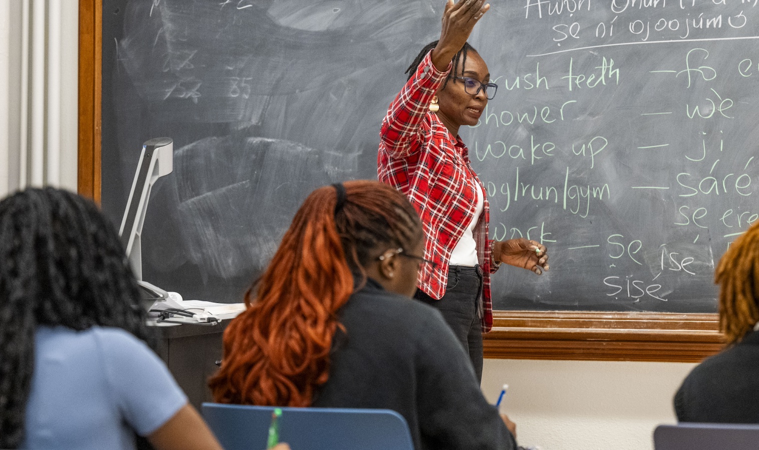 professor teaching class in front of a chalkboard